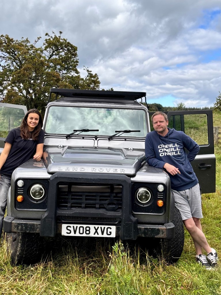 Steven and Alina from 3Farm Honey in beekeeping gear with hive equipment in the Land Rover.